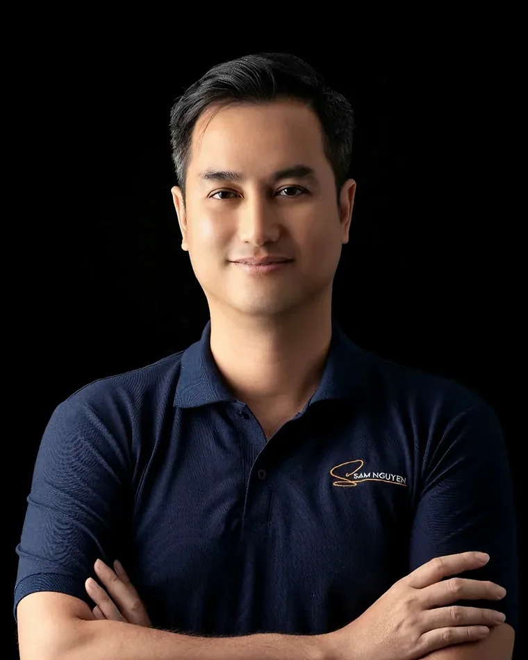 Chân dung Sam Nguyễn, áo polo xanh than, nền tối